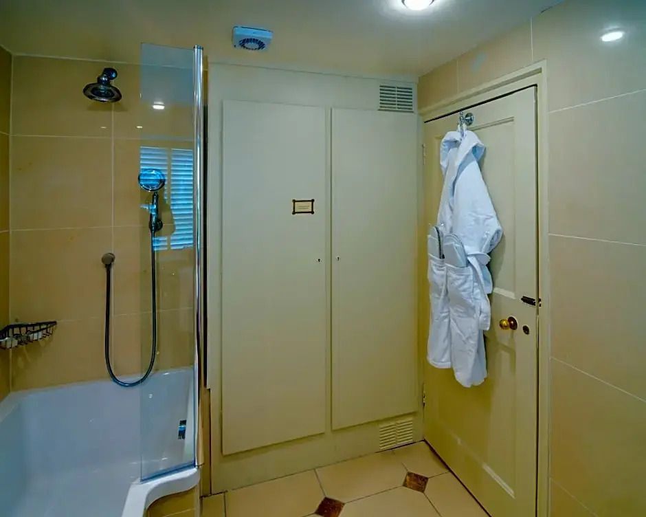 Modernes Badezimmer mit Dusche, Bademänteln und eleganten Fliesen