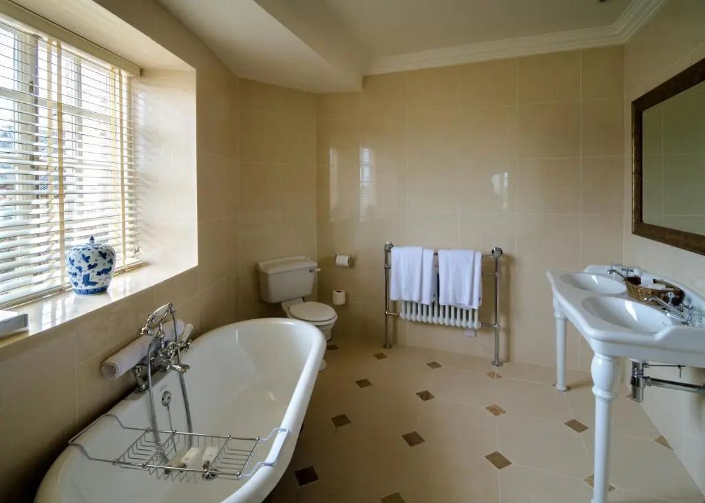 Geräumiges Badezimmer mit freistehender Badewanne und elegantem Fliesenboden