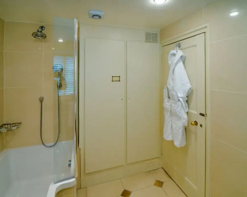 Dusche und Tür mit Bademantel im Badezimmer