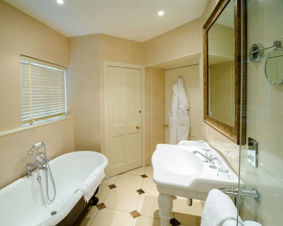 Badezimmer mit freistehender Badewanne und Spiegel
