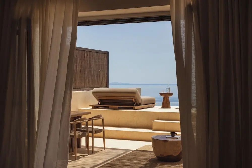Elegantes Zimmer mit öffnender Glasfront zur Terrasse und Meerblick