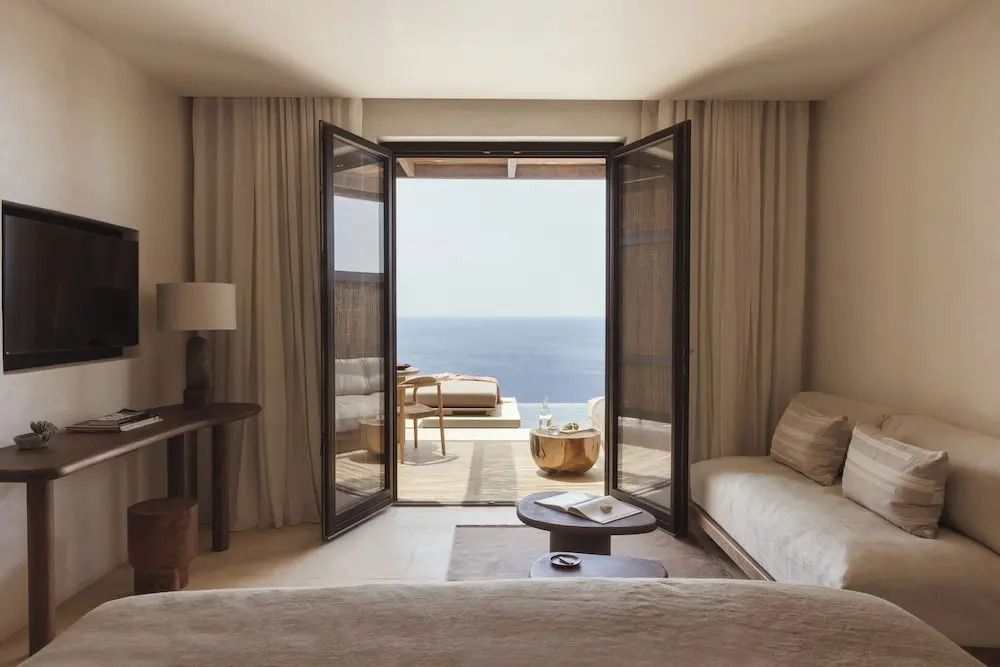 Wohnbereich der Suite mit offener Balkontür und Meerblick
