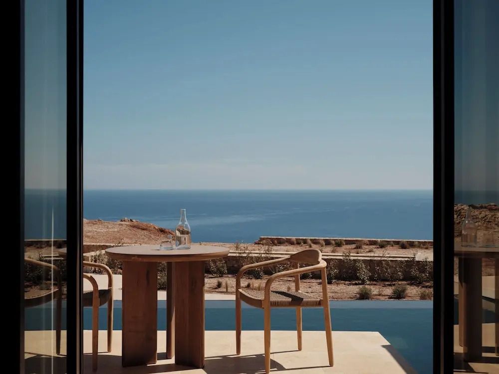 Terrassenansicht mit Tisch und Stühlen, Meer im Hintergrund