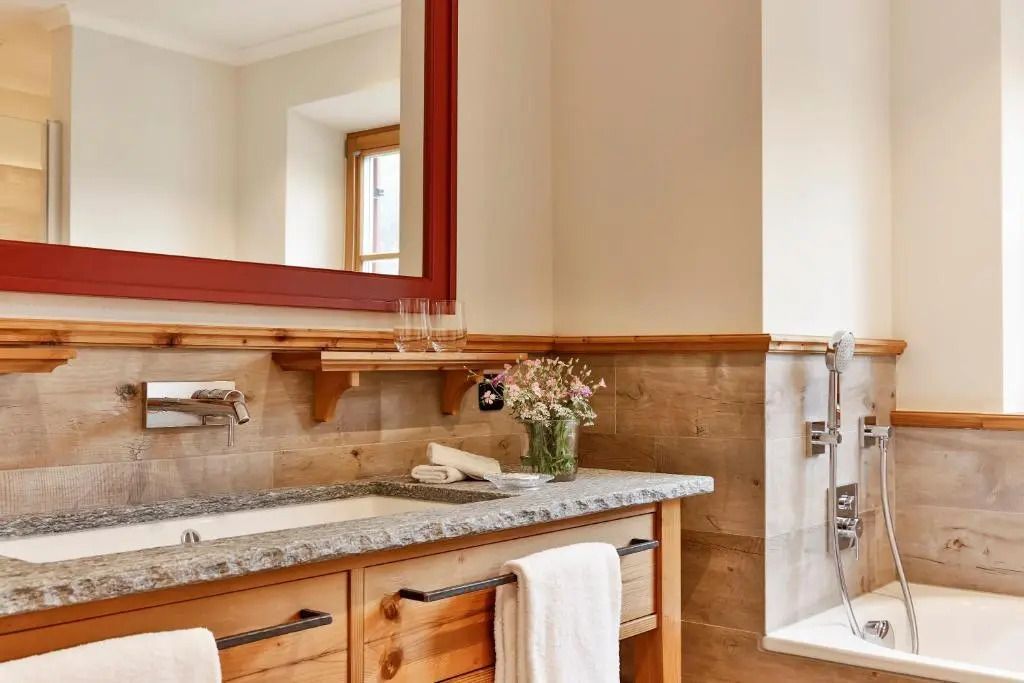Elegantes Badezimmer mit Holzdetails und großem Spiegel