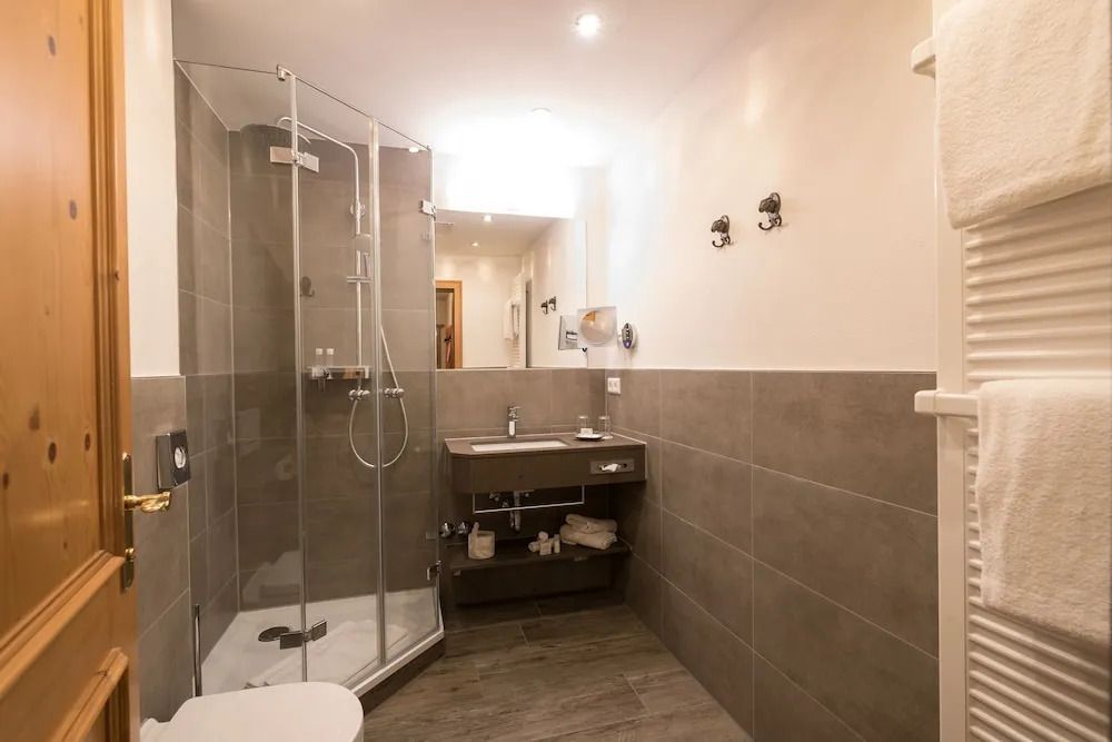 Modernes Badezimmer mit Dusche, Waschtisch und eleganter Beleuchtung