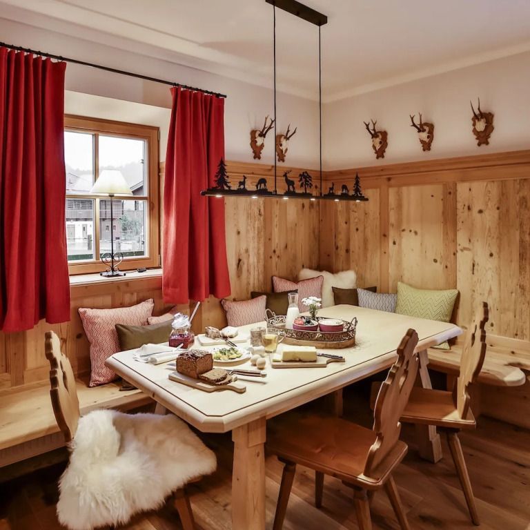 Gemütliche Sitzecke mit Holztisch und roten Vorhängen in traditionellem Stil