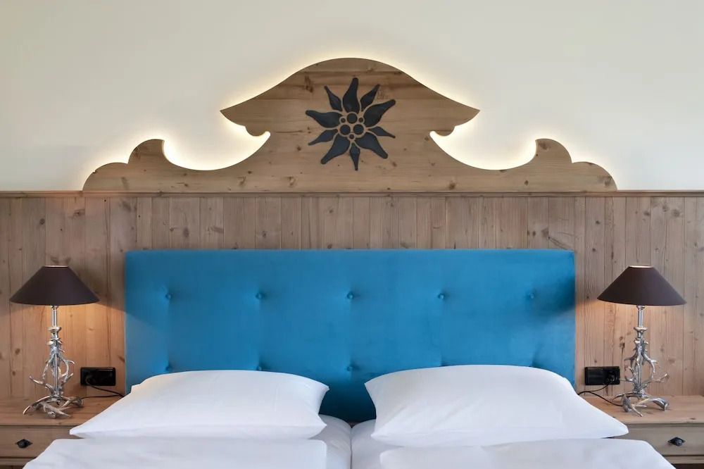 Bett mit blauer Polsterkopfstütze im alpinen Stil dekoriert
