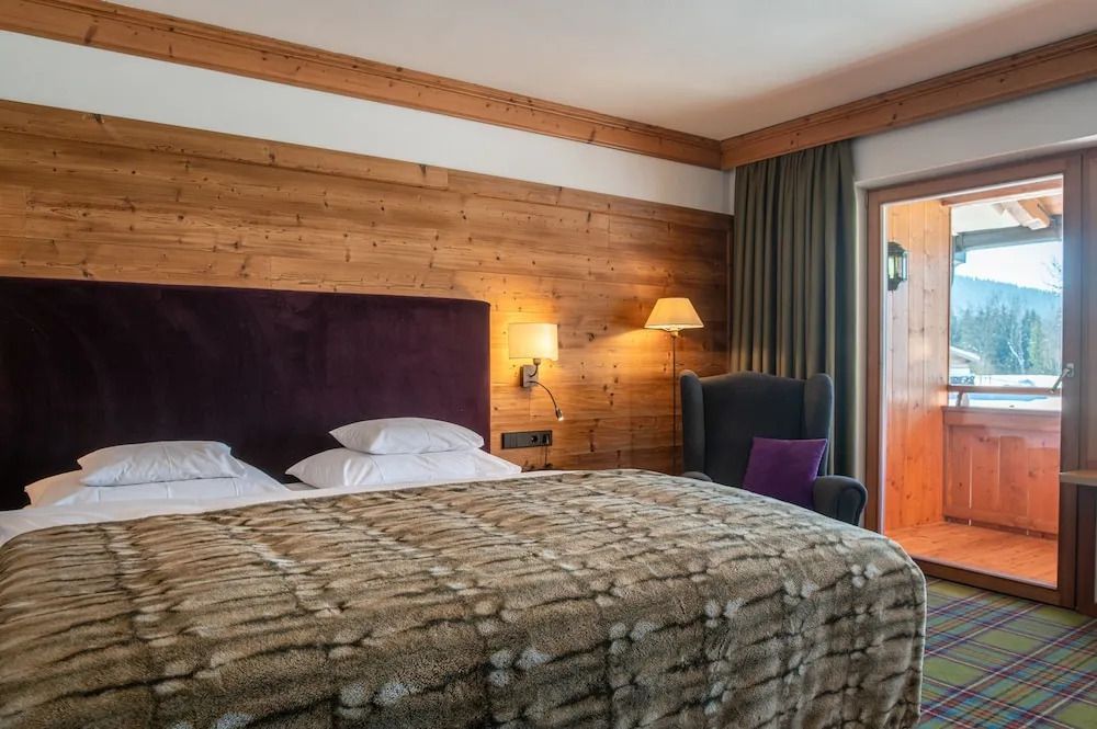 Gemütliches Zimmer mit Holzelementen und Balkonzugang
