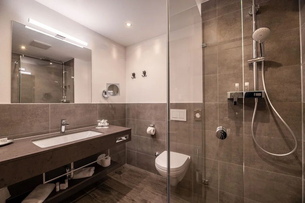 Modernes Badezimmer mit geräumiger Dusche und edlem Waschbereich in der Superior Suite.