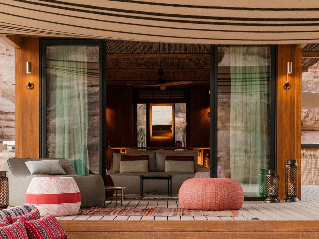 Terrassenblick auf ein stilvolles Zimmer mit großen Glasfenstern und gemütlicher Einrichtung