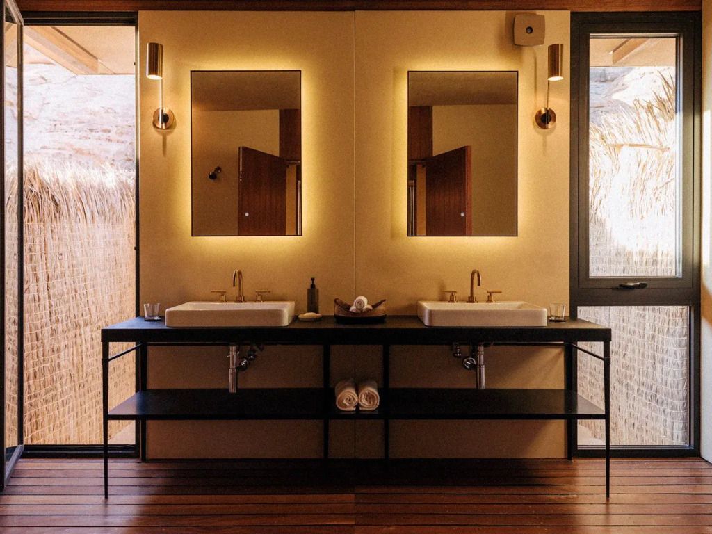 Modernes Badezimmer mit Doppelwaschbecken und beleuchteten Spiegeln