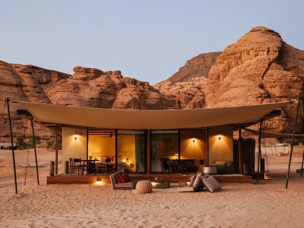 Luxuriöse Villa mit Glasfront inmitten der Wüstenlandschaft bei Abenddämmerung