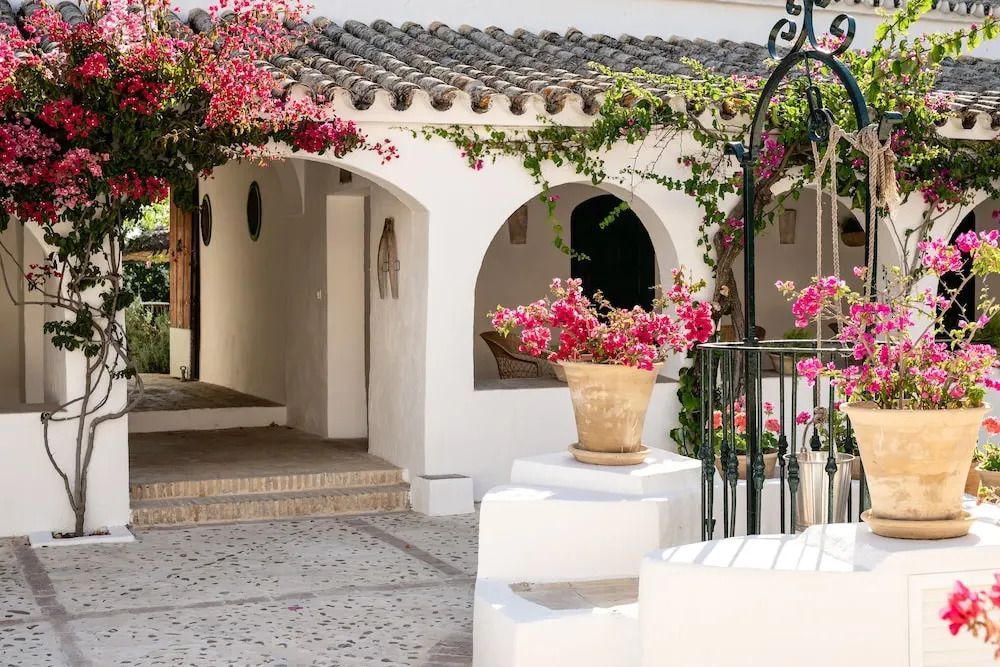 Hof mit blühenden Bougainvillea und traditionellen Bögen