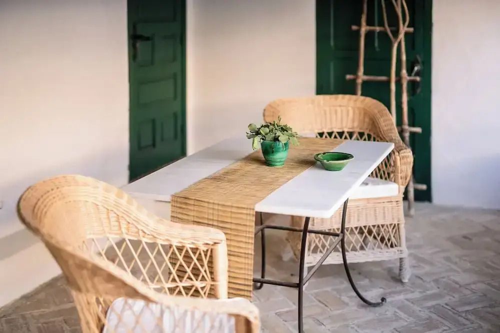 Rattanmöbel auf der Terrasse mit grünem Dekor und Pflanzen
