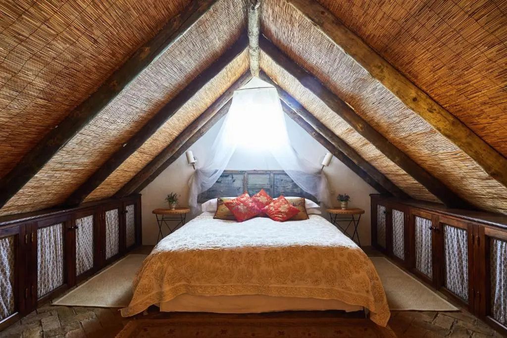 Charmantes Dachzimmer mit Holzbalken und einem großen Bett