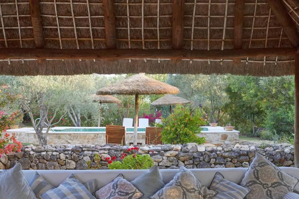 Entspannungsbereich mit Blick auf Pool und üppigen Garten