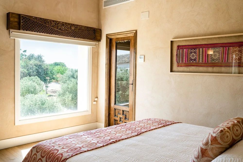 Gemütliches Schlafzimmer mit großen Fenstern und traditionellem Dekor.