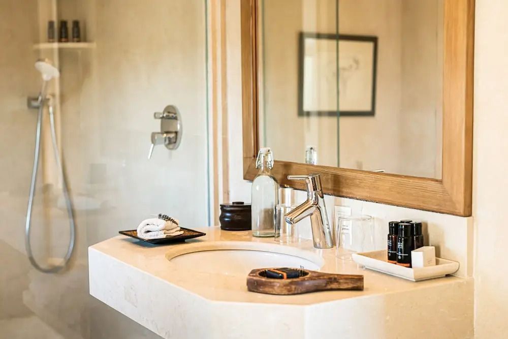 Modernes Badezimmer mit Waschbecken und großen Spiegeln in natürlichem Dekor.
