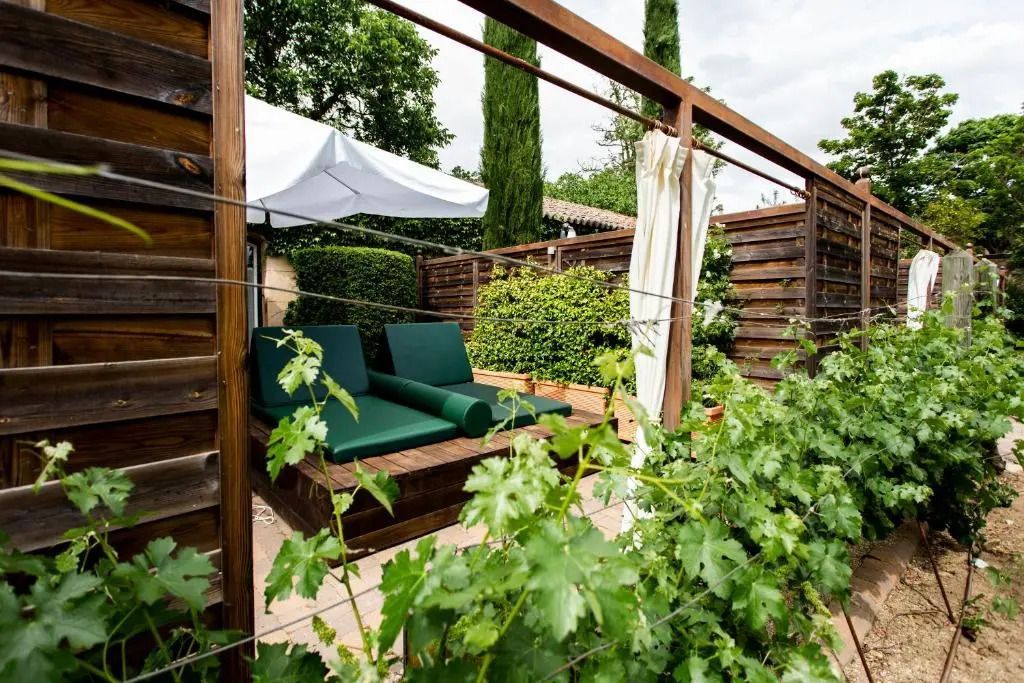 Private Gartenlounge mit Holzlatten und modernen Liegen