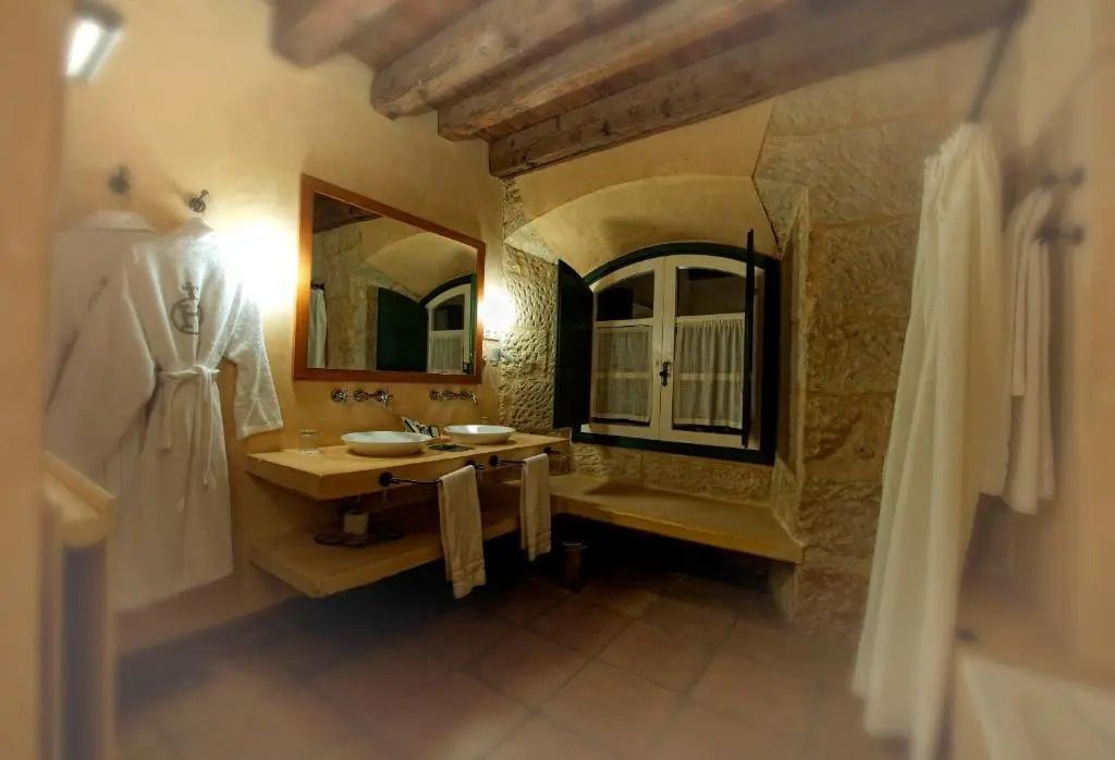 Badezimmer mit Doppelwaschbecken und rustikalen Elementen im Hacienda Zorita Wine Hotel