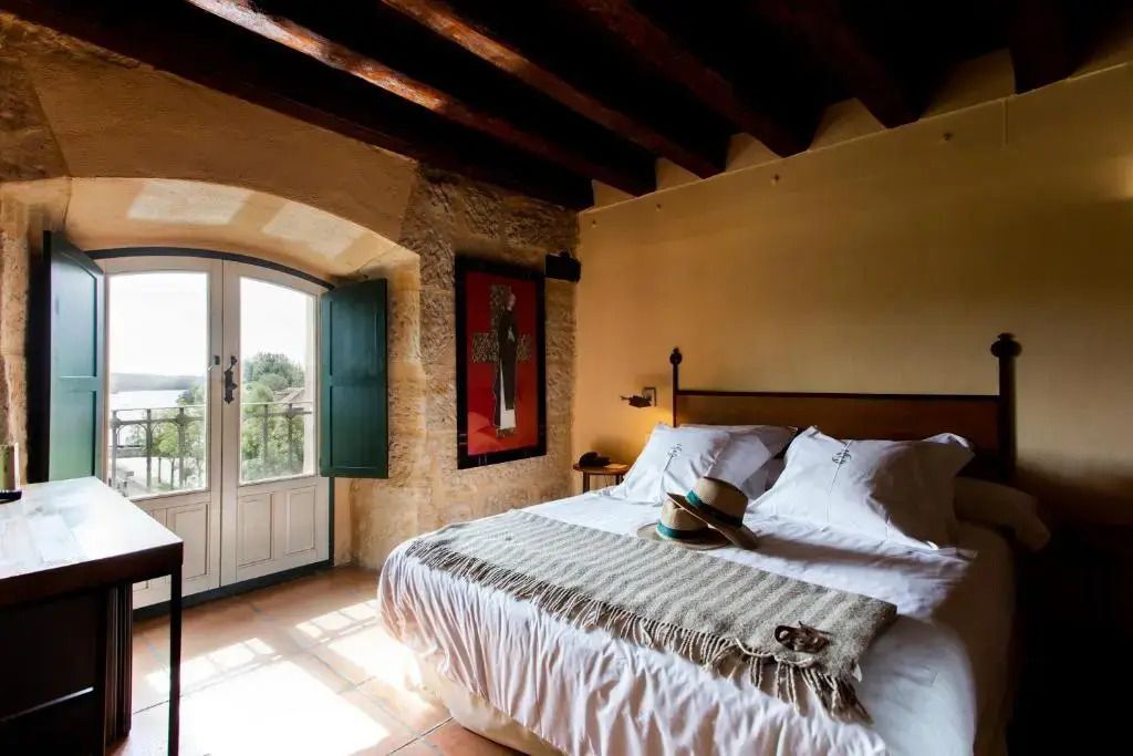 Helles Doppelzimmer mit Steinwand und rustikaler Einrichtung im Hotel Hacienda Zorita.