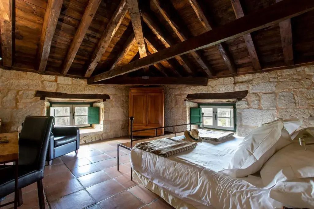 Rustikales Schlafzimmer mit Holzbalken und Doppelbett in gemütlicher Atmosphäre