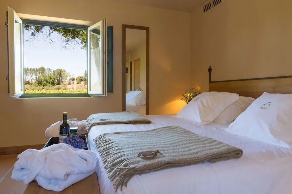 Hotelzimmer mit Blick auf einen grünen Garten durch ein offenes Fenster