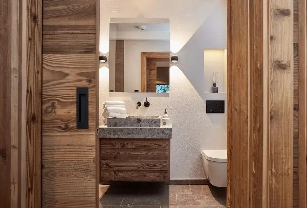 Modernes Badezimmer mit Holzverkleidung und großem Spiegel