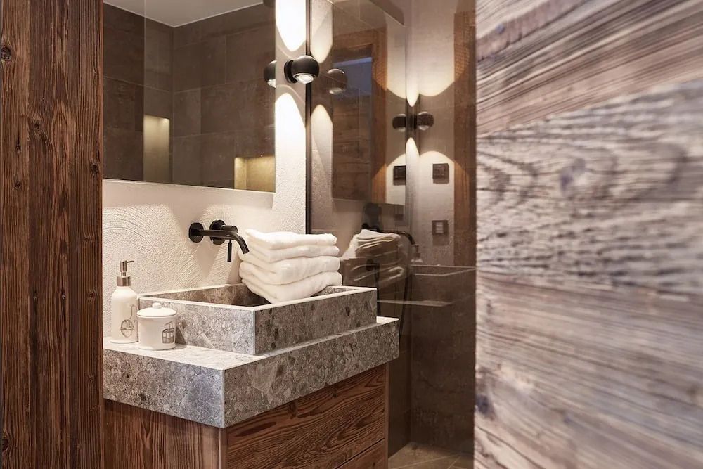 Modernes Badezimmer mit stilvollen Holzelementen und eleganter Steinwaschbecken