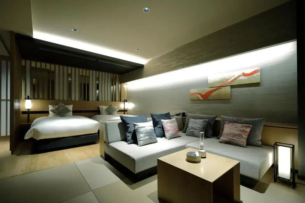 Gemütlicher Wohnbereich mit Sofa und Kunstwand in einem luxuriösen Hotelzimmer