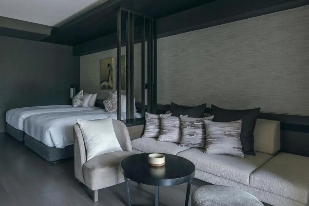 Gemütliche Sitzecke im Hotelzimmer neben zwei Einzelbetten