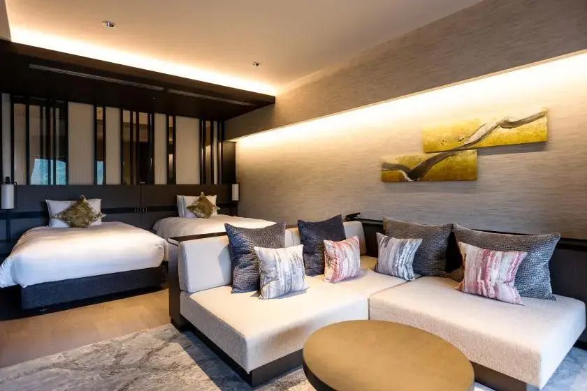 Geräumiges Hotelzimmer mit zwei Einzelbetten und Sofa im modernen japanischen Stil