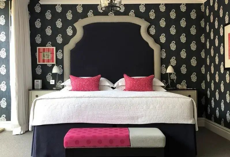 Komfortables Deluxe Zimmer mit Doppelbett und stilvollen Tapeten