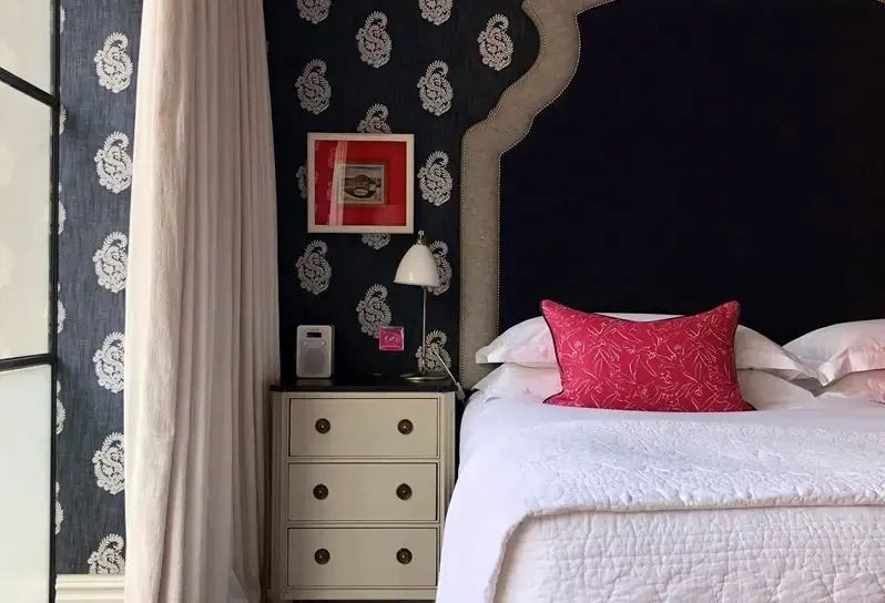 Nachtisch mit Lampe und Kunstwerk in einem stilvollen Hotelzimmer