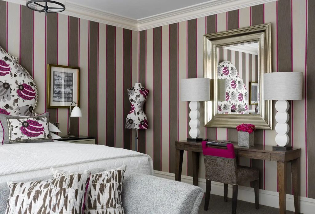 Hotelzimmer mit stilvollen Streifenwänden und eleganter Spiegelkommode