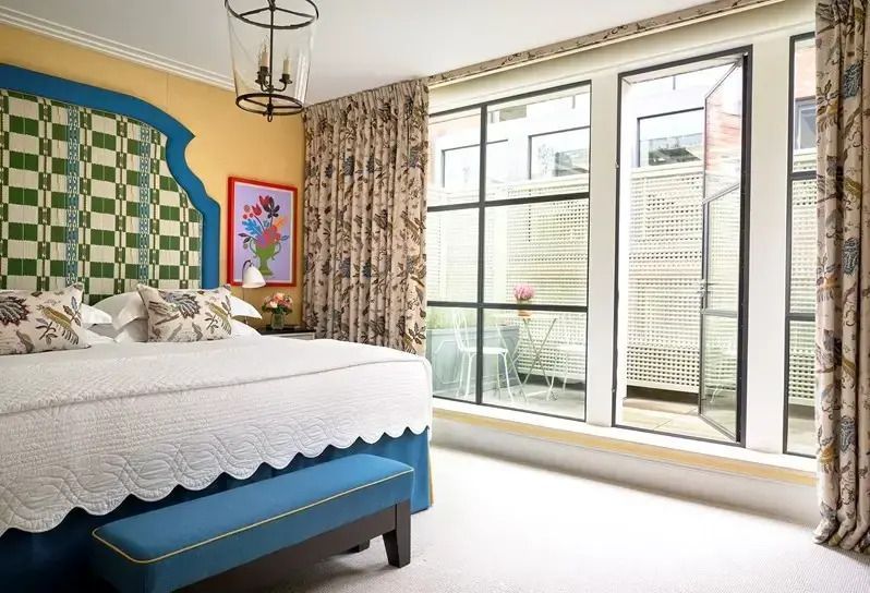 Schlafzimmer mit Zugang zu einem Balkon durch große Fenster