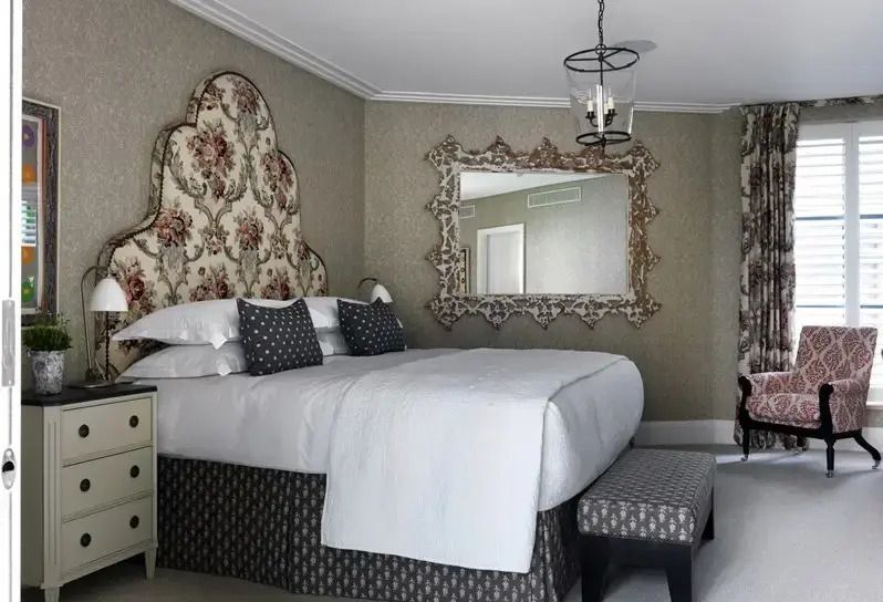 Edles Schlafzimmer in Grautönen mit kunstvollem Spiegel und Blumenmuster