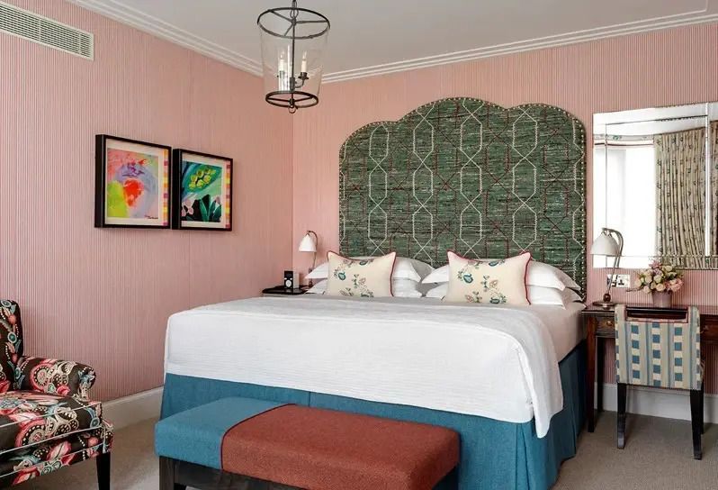 Luxuriöse Suite mit großem Doppelbett und eleganten Details in sanften Farben