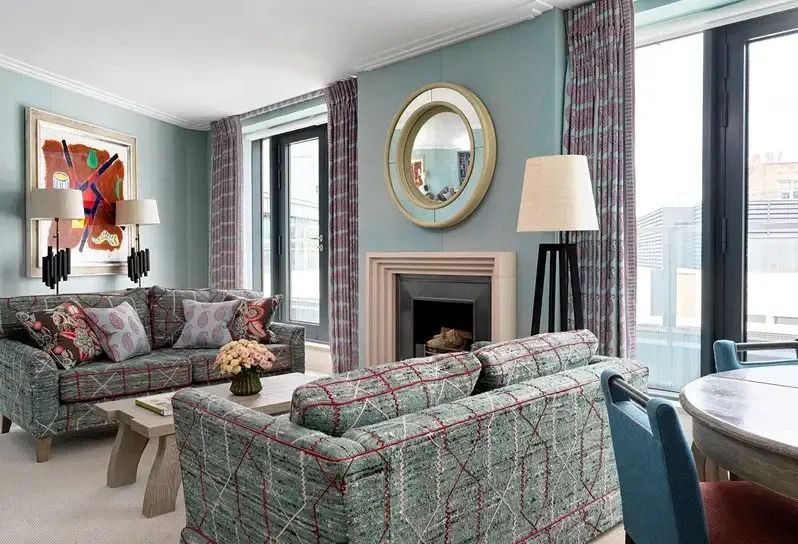 Gemütlicher Wohnbereich mit Kamin und eleganten Sofas in einer Suite