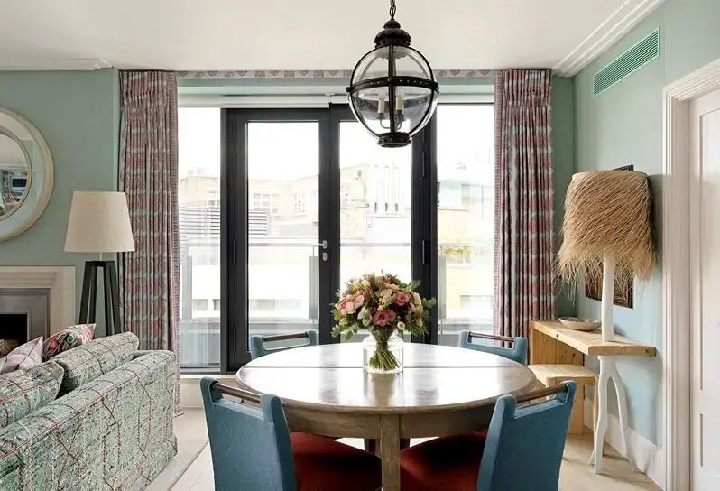Essbereich mit rundem Tisch und Blumenarrangement in einer luxuriösen Suite
