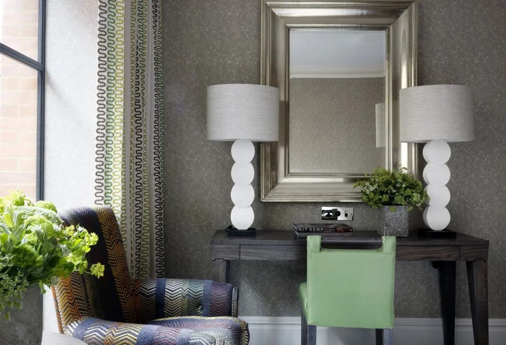 Schreibtisch mit dekorativem Spiegel und moderner Tischlampe in einem luxuriösen Hotelzimmer