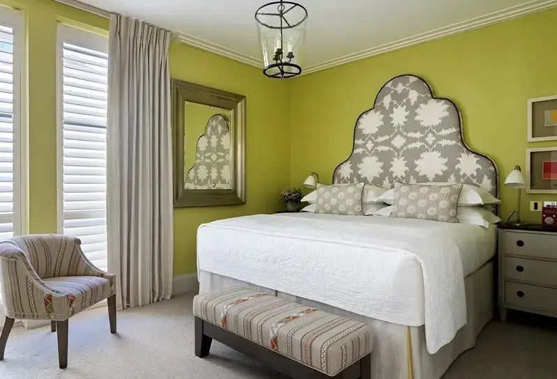 Schlafzimmer mit Bett und stilvollem Kopfteil in grünem Ambiente