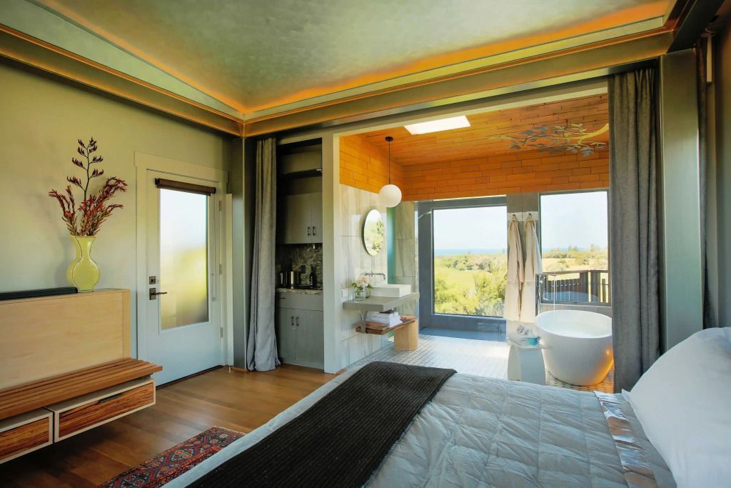 Helles Zimmer mit Blick auf die Landschaft, modernes Interieur und freistehende Badewanne