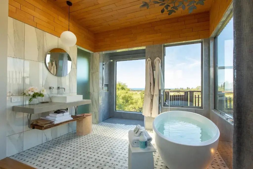 Modernes Badezimmer mit freistehender Badewanne und großer Fensterfront