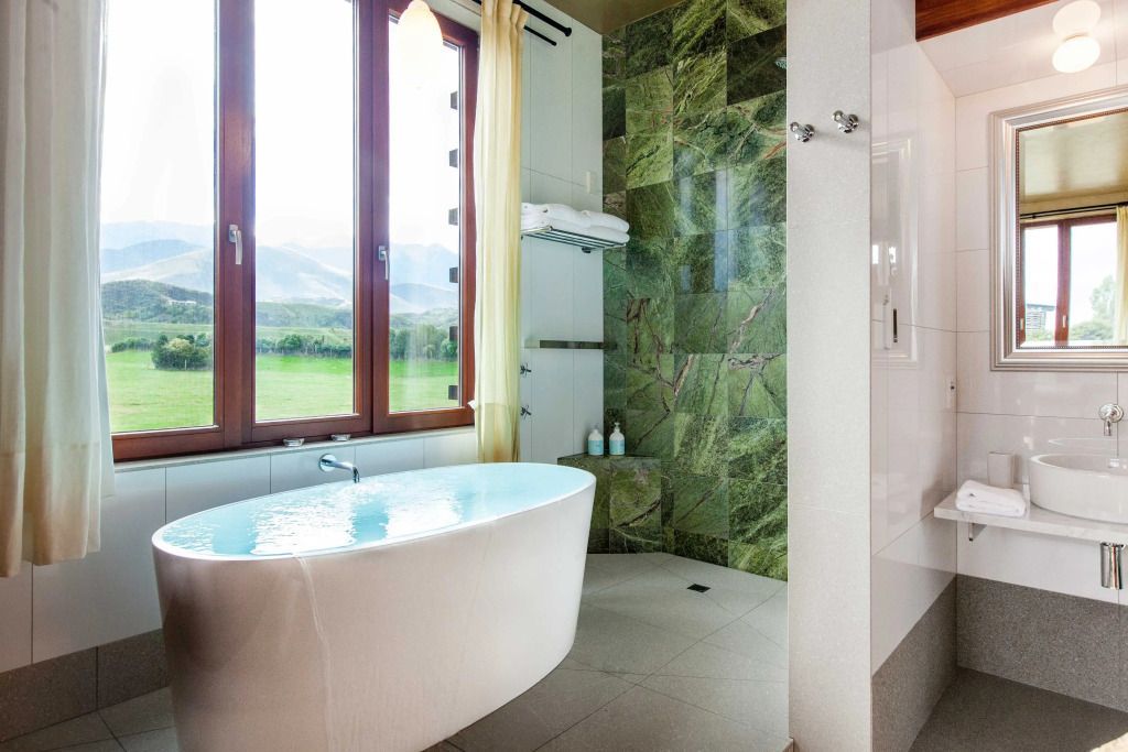 Freistehende Badewanne mit Blick auf grüne Landschaft