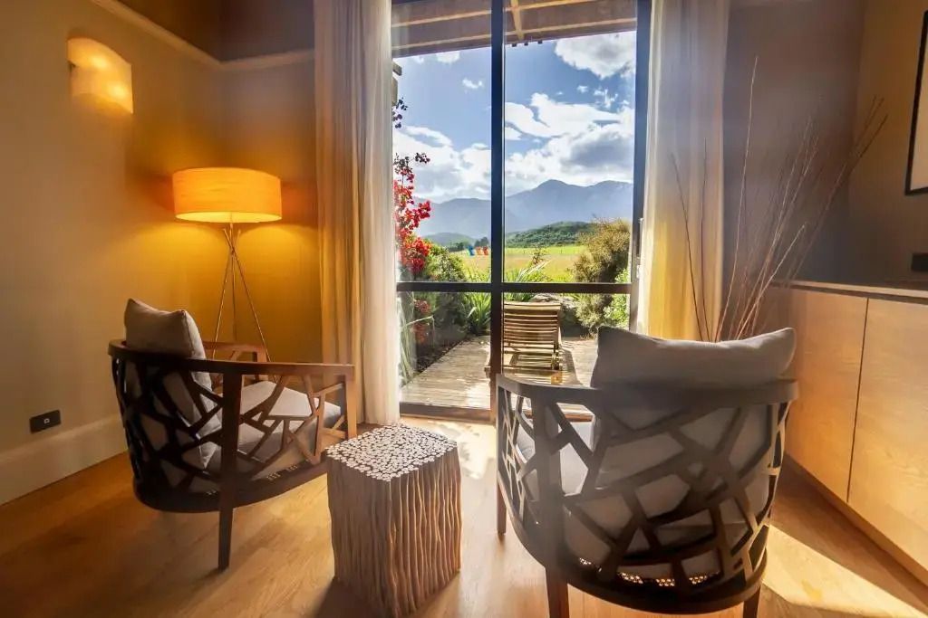 Sitzecke in der Suite mit Blick auf die Berge und üppige Landschaft