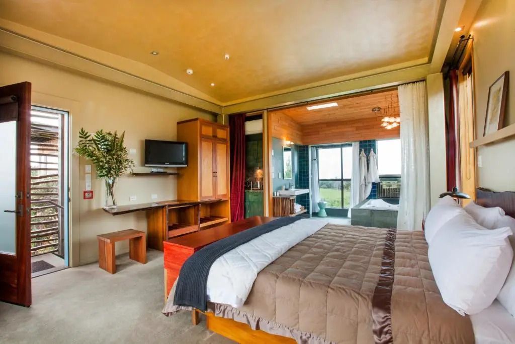 Großes Doppelbett mit flauschiger Decke und integriertem Bad in der Suite.