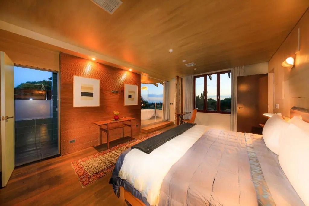 Modernes Schlafzimmer mit Doppelbett und großem Fensterblick