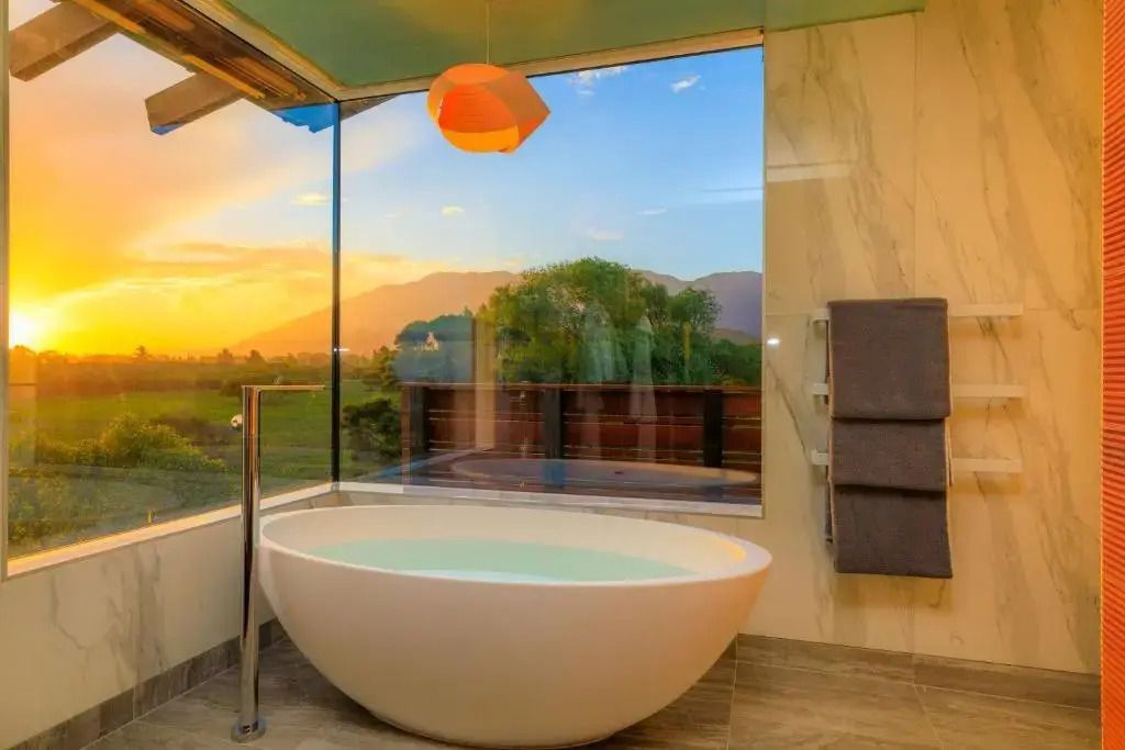 Freistehende Badewanne mit Panoramablick auf Berge im Sonnenuntergang