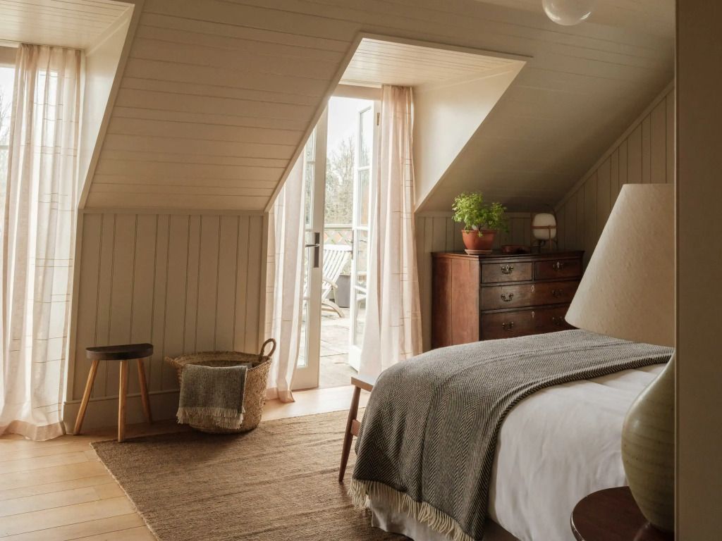 Schlafzimmer unterm Dach mit Zugang zur Terrasse und viel Tageslicht.